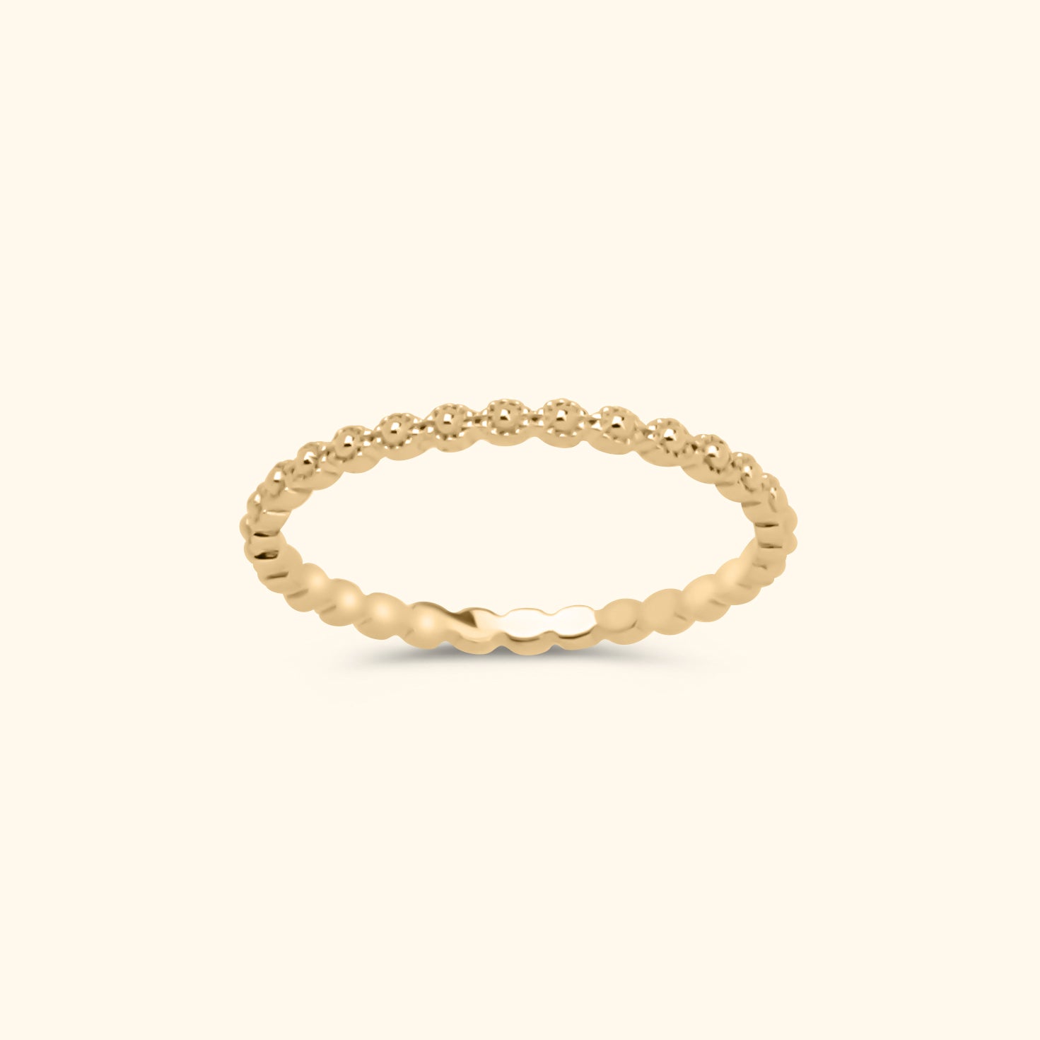 Goudkleurige stapelring van gold plated messing met een patroon van kleine bolletjes rondom de band.